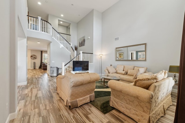 2865 Maine Ave, Clovis, CA 93619 - living room featuring a high ceiling, light wood finished floors, stairs, and baseboards