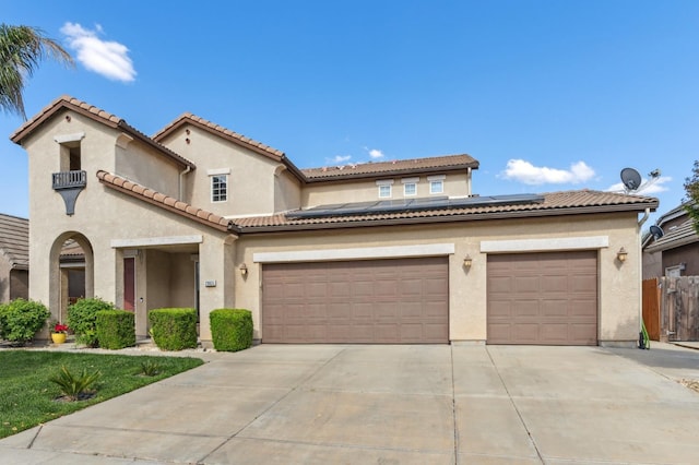 2865 Maine Ave, Clovis, CA 93619 - mediterranean / spanish-style house with concrete driveway, roof mounted solar panels, stucco siding, and fence