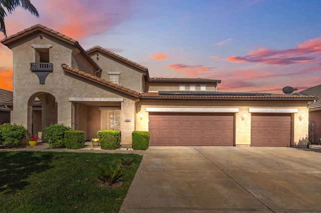 2865 Maine Ave, Clovis, CA 93619 - mediterranean / spanish-style home with driveway, stucco siding, an attached garage, a tile roof, and a front lawn