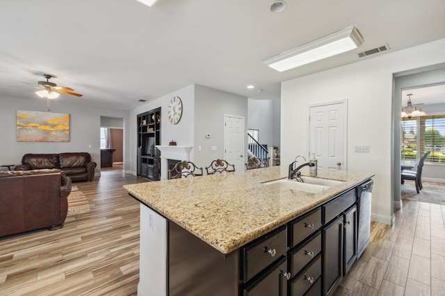 2865 Maine Ave, Clovis, CA 93619 - kitchen with a sink, light wood-style flooring, dishwasher, a chandelier, and light stone counters