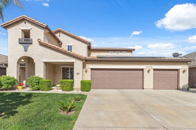 2865 Maine Ave, Clovis, CA 93619 - mediterranean / spanish home featuring concrete driveway, stucco siding, a front lawn, and a tile roof