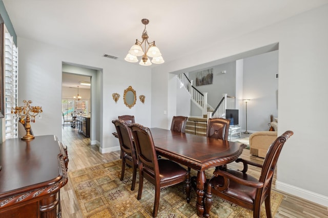 2865 Maine Ave, Clovis, CA 93619 - dining room with a chandelier, light wood-type flooring, stairs, and baseboards
