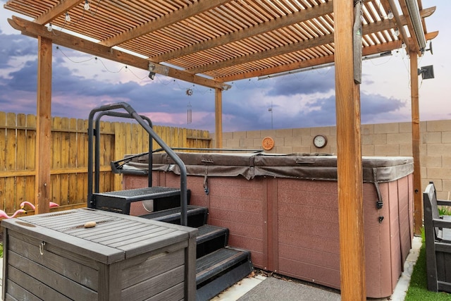 patio terrace at dusk featuring a fenced backyard, a hot tub, and a pergola