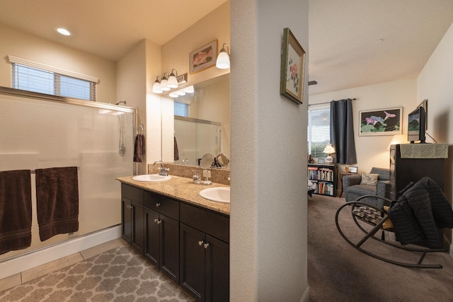 bathroom featuring an enclosed shower, double vanity, and recessed lighting