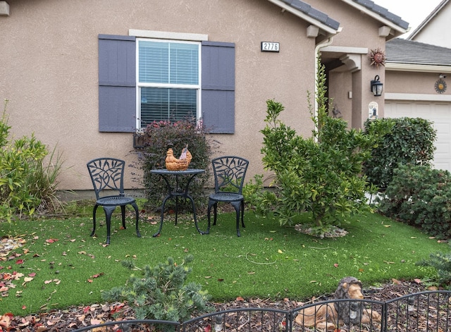 view of property exterior featuring stucco siding, a lawn, and an attached garage