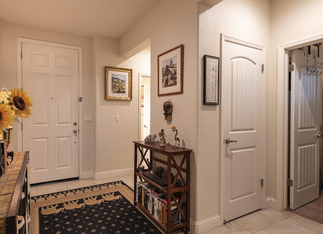 foyer with light tile patterned floors and baseboards