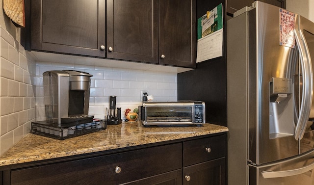 kitchen with backsplash, stainless steel fridge with ice dispenser, and dark brown cabinetry