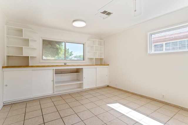 324 E San Mateo St, Avenal, CA 93204 - kitchen featuring open shelves, healthy amount of natural light, white cabinets, light tile patterned floors, and crown molding