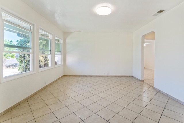 324 E San Mateo St, Avenal, CA 93204 - unfurnished room featuring arched walkways, light tile patterned flooring, and baseboards