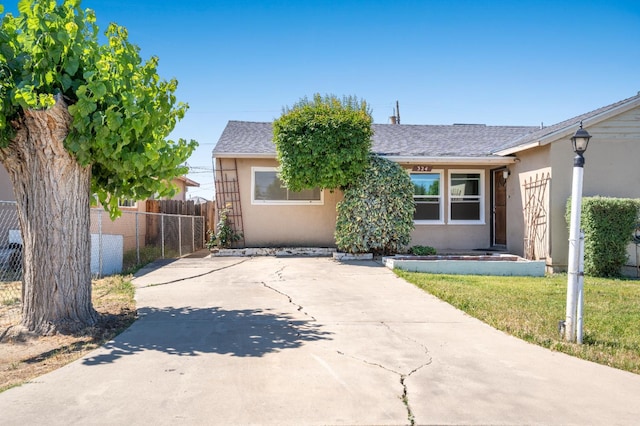 324 E San Mateo St, Avenal, CA 93204 - view of front of house with stucco siding, driveway, and a shingled roof