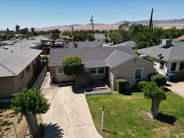 324 E San Mateo St, Avenal, CA 93204 - view of front of property featuring a mountain view, central AC, a front yard, and a shingled roof