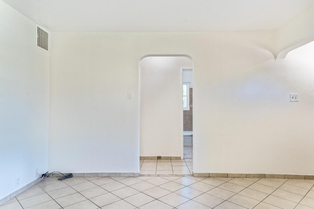324 E San Mateo St, Avenal, CA 93204 - unfurnished room with light tile patterned floors, arched walkways, and baseboards