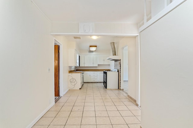 324 E San Mateo St, Avenal, CA 93204 - kitchen with gas range oven, a sink, white cabinetry, and baseboards