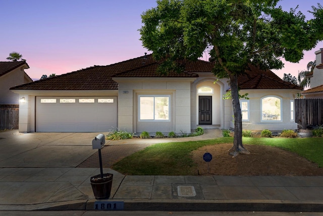 1801 E Omaha Ave, Fresno, CA 93720 - ranch-style home featuring driveway, a tiled roof, an attached garage, fence, and stucco siding