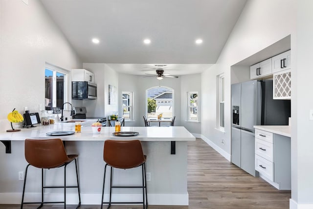 1801 E Omaha Ave, Fresno, CA 93720 - kitchen featuring appliances with stainless steel finishes, a sink, a peninsula, lofted ceiling, and a breakfast bar