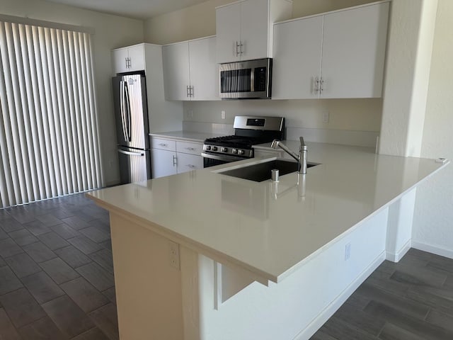 663 Farmhouse Ln, Clovis, CA 93619 - kitchen featuring stainless steel appliances, a peninsula, a sink, light countertops, and white cabinetry