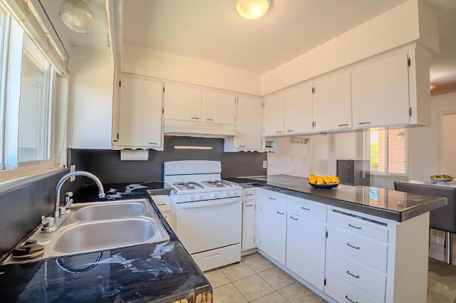 1380 Elaine Dr, Hanford, CA 93230 - kitchen featuring white range with gas cooktop, under cabinet range hood, a peninsula, and white cabinetry