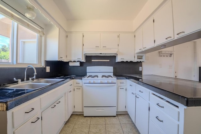 1380 Elaine Dr, Hanford, CA 93230 - kitchen featuring white gas stove, white cabinets, tasteful backsplash, and dark countertops