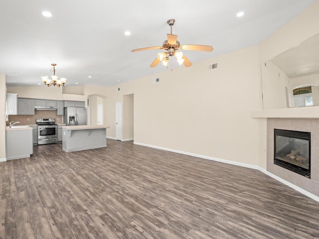 5611 W Carmen Ave, Fresno, CA 93722 - unfurnished living room with dark wood-style flooring, recessed lighting, ceiling fan, a chandelier, and baseboards