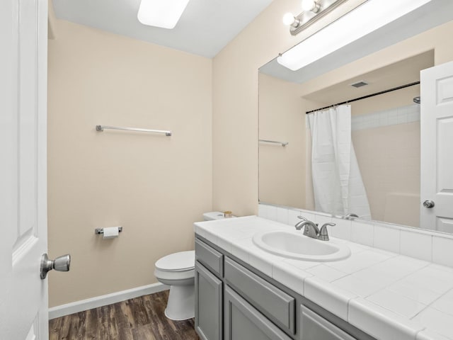 5611 W Carmen Ave, Fresno, CA 93722 - full bathroom with baseboards, wood finished floors, toilet, vanity, and curtained shower
