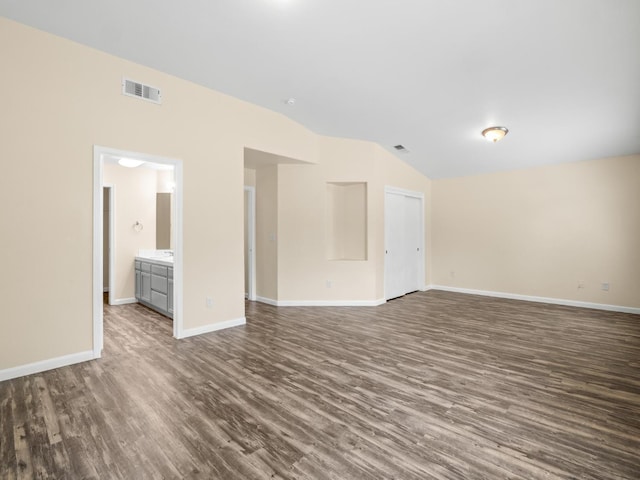 5611 W Carmen Ave, Fresno, CA 93722 - unfurnished living room featuring dark wood-style flooring, vaulted ceiling, and baseboards