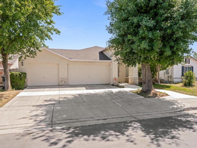 5611 W Carmen Ave, Fresno, CA 93722 - view of front facade featuring stone siding, an attached garage, concrete driveway, stucco siding, and a shingled roof