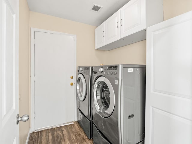 5611 W Carmen Ave, Fresno, CA 93722 - clothes washing area with washer and clothes dryer, dark wood-style floors, and cabinet space