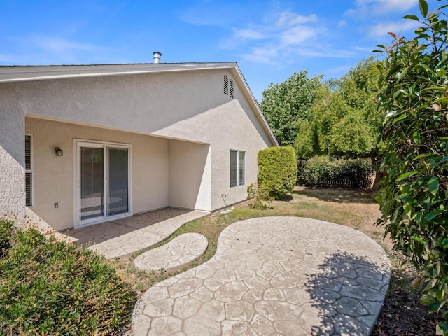 5611 W Carmen Ave, Fresno, CA 93722 - back of house with stucco siding and a patio