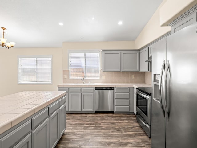 5611 W Carmen Ave, Fresno, CA 93722 - kitchen featuring stainless steel appliances, gray cabinetry, tile counters, dark wood finished floors, and recessed lighting