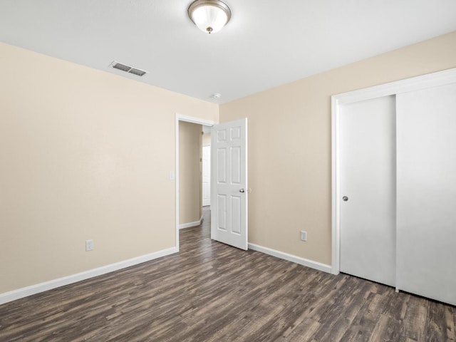 5611 W Carmen Ave, Fresno, CA 93722 - unfurnished bedroom with dark wood-style floors, baseboards, and a closet