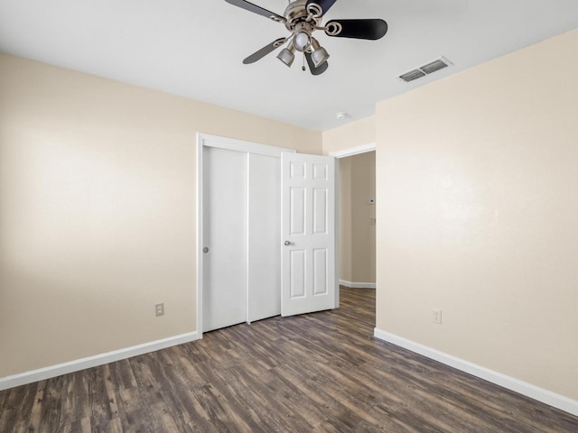 5611 W Carmen Ave, Fresno, CA 93722 - unfurnished bedroom featuring dark wood-type flooring, baseboards, a closet, and a ceiling fan