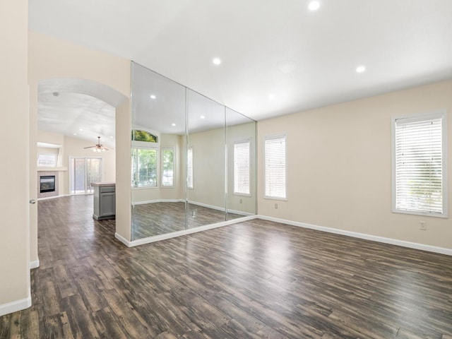 5611 W Carmen Ave, Fresno, CA 93722 - unfurnished living room featuring arched walkways, dark wood finished floors, baseboards, recessed lighting, and ceiling fan