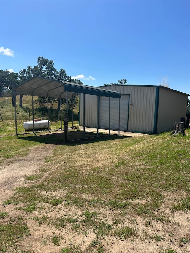 15501 Garlock Ln, Prather, CA 93651 - view of grassy yard with an outbuilding, a garage, dirt driveway, and a carport