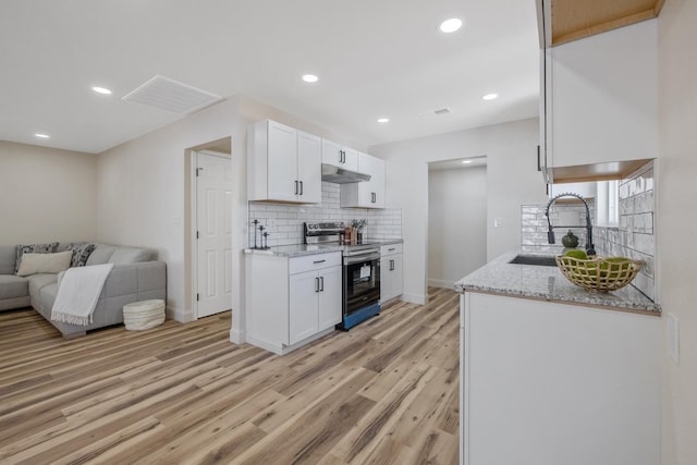 336 W Locust Ave, Pinedale, CA 93650 - kitchen with stainless steel electric range, a sink, under cabinet range hood, open floor plan, and tasteful backsplash