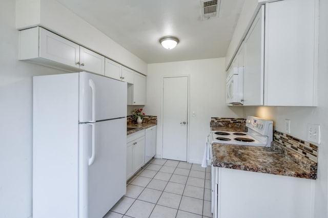 kitchen with white appliances, dark countertops, white cabinetry, and light tile patterned floors