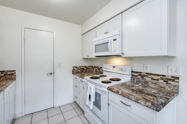 kitchen featuring white appliances, decorative backsplash, white cabinets, light tile patterned floors, and dark stone countertops
