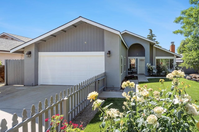 5298 N Reese Ave, Fresno, CA 93722 - view of front of home featuring an attached garage, driveway, fence, stucco siding, and a chimney