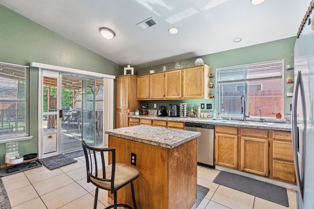 5532 W Indianapolis Ave, Fresno, CA 93722 - kitchen featuring dishwasher, vaulted ceiling, a sink, a center island, and light tile patterned flooring