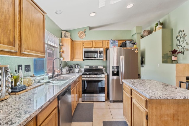 5532 W Indianapolis Ave, Fresno, CA 93722 - kitchen featuring stainless steel appliances, a sink, light tile patterned floors, light stone counters, and a center island