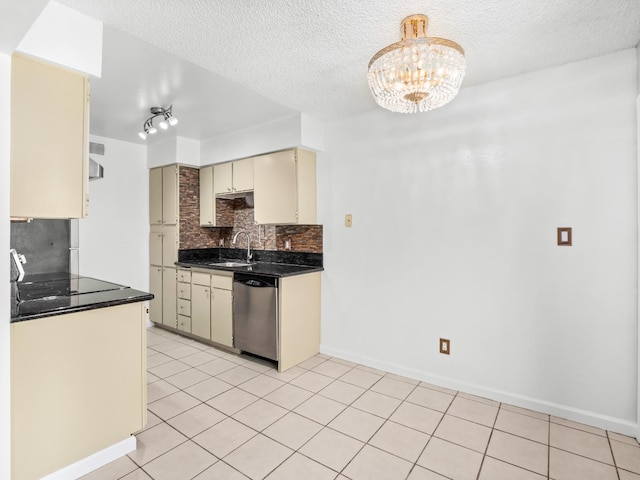 1550 W Ashlan Ave Unit 241, Fresno, CA 93705 - kitchen featuring stainless steel dishwasher, cream cabinetry, dark countertops, a sink, and tasteful backsplash