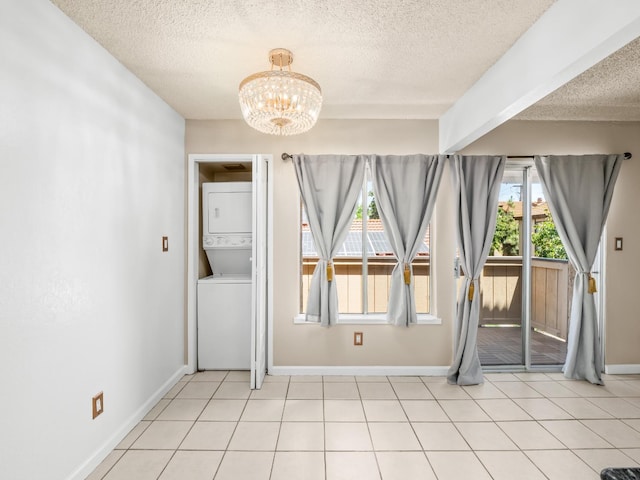 1550 W Ashlan Ave Unit 241, Fresno, CA 93705 - spare room with stacked washing machine and dryer, a textured ceiling, a chandelier, and baseboards