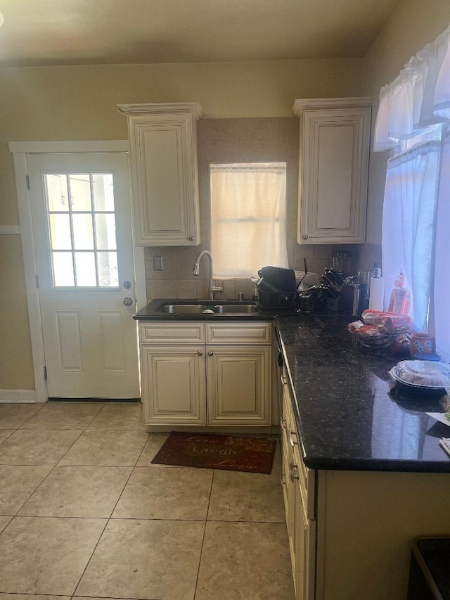 814 N Roosevelt Ave, Fresno, CA 93728 - kitchen featuring a sink, tasteful backsplash, light tile patterned floors, and white cabinetry