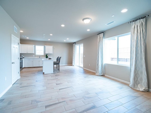 873 Beaver Pond Loop, Madera, CA 93636 - kitchen featuring recessed lighting, gas stove, a breakfast bar, white cabinetry, and baseboards