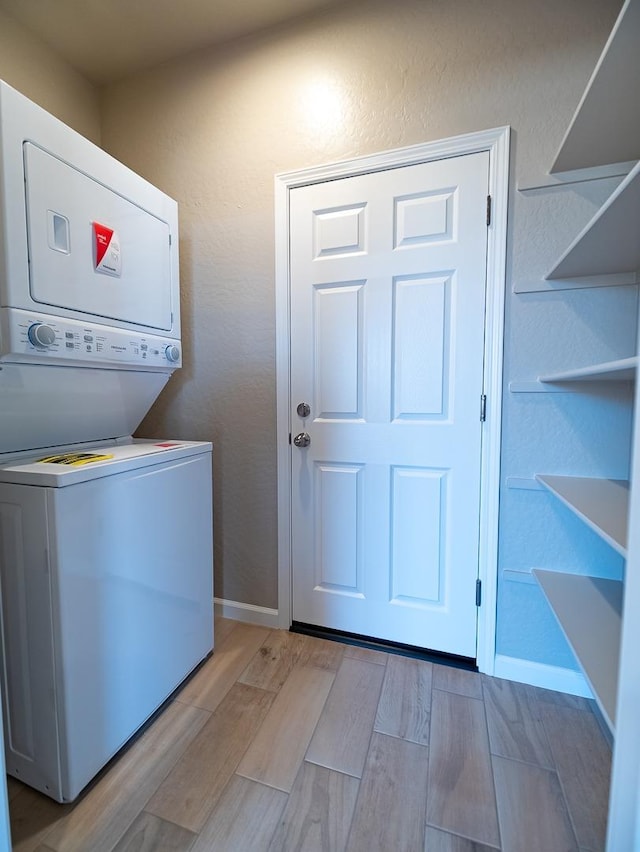 873 Beaver Pond Loop, Madera, CA 93636 - clothes washing area featuring estacked washer and dryer, light wood-type flooring, and baseboards