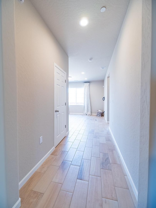 873 Beaver Pond Loop, Madera, CA 93636 - corridor with wood tiled floors, a textured wall, baseboards, and recessed lighting