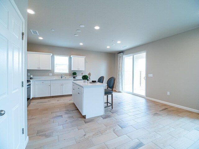 873 Beaver Pond Loop, Madera, CA 93636 - kitchen with a sink, a kitchen breakfast bar, a kitchen island with sink, gas stove, and recessed lighting