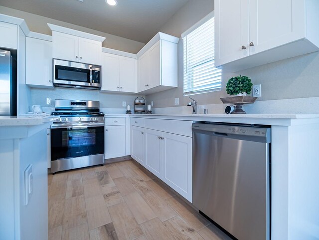 873 Beaver Pond Loop, Madera, CA 93636 - kitchen featuring stainless steel appliances, white cabinets, recessed lighting, light wood-style flooring, and a sink