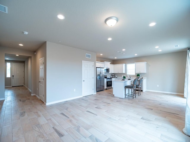873 Beaver Pond Loop, Madera, CA 93636 - kitchen featuring stainless steel appliances, open floor plan, recessed lighting, a kitchen bar, and baseboards