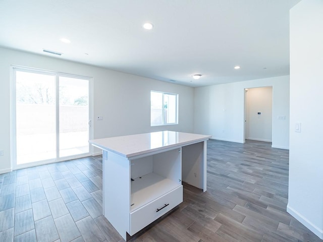 878 Beaver Pond Loop, Madera, CA 93636 - kitchen with a center island, light countertops, baseboards, wood finished floors, and recessed lighting