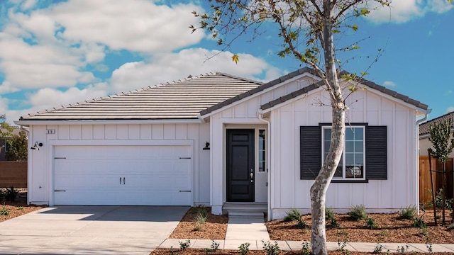 878 Beaver Pond Loop, Madera, CA 93636 - view of front of property featuring board and batten siding, a tiled roof, an attached garage, driveway, and fence